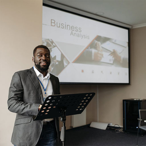 Speaker behind podium with Business Analysis presentation