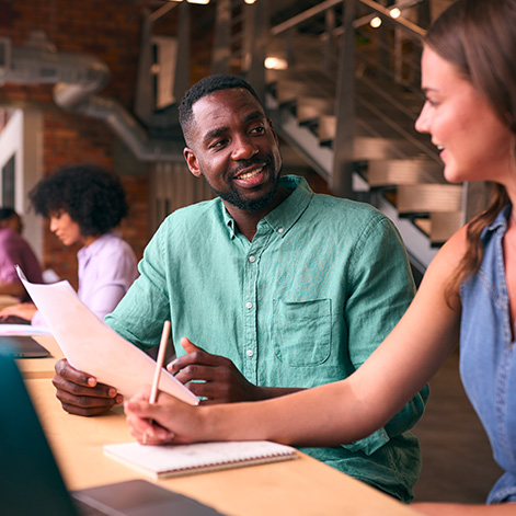 Colleagues having discussion at meeting table in office