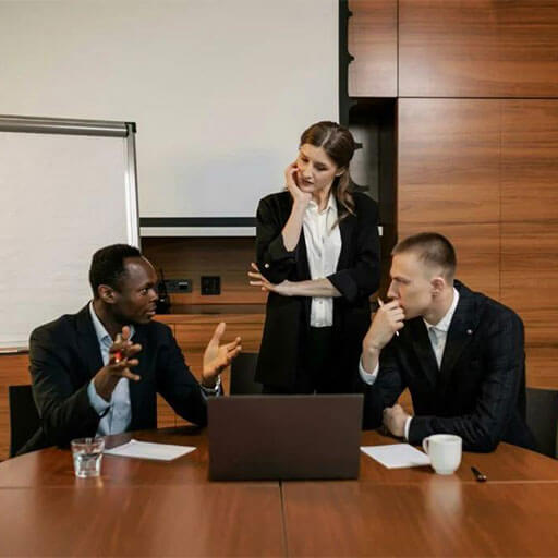 Three colleagues in boardroom with strategy plan